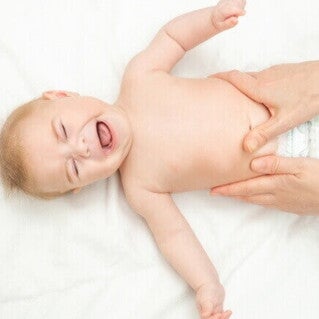 Bebê chorando com dor abdominal, um dos sintomas de alergia à proteína do leite de vaca (APLV).