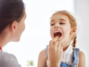 uma médica examinando a boca de uma menina criança uma médica examinando a boca de uma menina criança