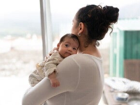 Mamãe segurando o bebê com o nariz entupido