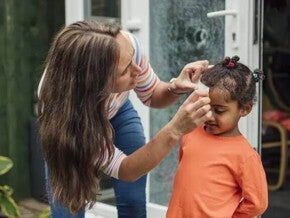Mãe faz um curativo em criança que bateu a cabeça Mãe faz um curativo em criança que bateu a cabeça