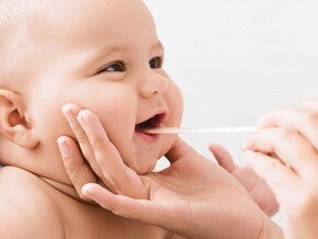 Bebê sendo examinado com palito abaixador de língua Bebê sendo examinado com palito abaixador de língua