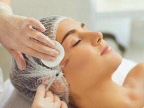 Close-up de uma mulher recebendo uma injeção de Botox ou preenchimento facial em uma clínica de estética, com a profissional usando luvas e uma seringa, representando o procedimento estético.