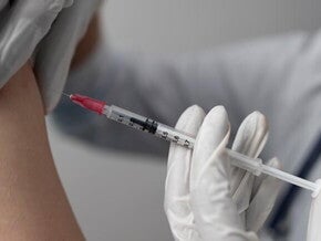 Imagem de um profissional de saúde aplicando uma injeção no braço de um pessoa Imagem de um profissional de saúde aplicando uma injeção no braço de um pessoa