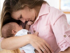 Mãe segurando e ninando o filho recém nascido Mãe segurando e ninando o filho recém nascido