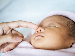 mão de um adulto tocando o rosto de um recém-nascido mão de um adulto tocando o rosto de um recém-nascido