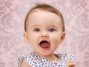 Bebê com a boca aberta sob um fundo rosa