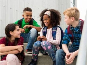 Um grupo de jovens sentados na escada e sorrindo