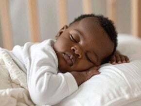 Bebê dormindo tranquilamente em um ambiente acolhedor, representando momentos de descanso em meio à regressão do sono dos 2 anos.