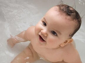 Um bebê dentro da banheira com a boca aberta