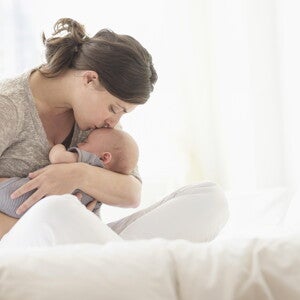 Mother kissing sleeping baby Mother kissing sleeping baby