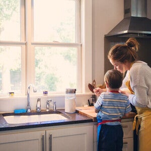 Criança ajudando um adulto na cozinha durante uma atividade juntos