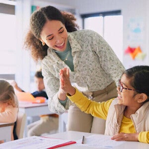 Criança estudando com livros e materiais escolares em uma mesa, representando aprendizado e desenvolvimento