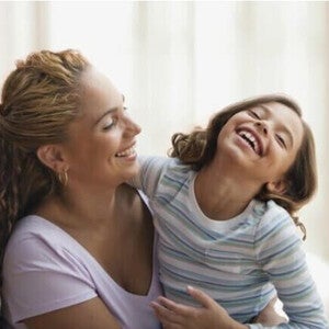 Mamá y niña de preescolar riendo al decir trabalenguas