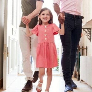 Uma menina com aspecto de felicidade, andando de mãos dadas com dois homens em um ambiente doméstico. Uma menina com aspecto de felicidade, andando de mãos dadas com dois homens em um ambiente doméstico.