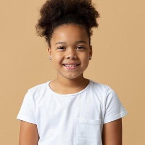 Menina com cabelo preso e camiseta branca sorrindo Menina com cabelo preso e camiseta branca sorrindo