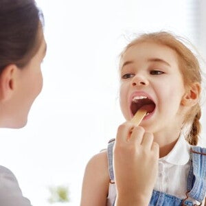 uma médica examinando a boca de uma menina criança uma médica examinando a boca de uma menina criança