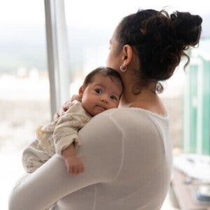 Mamãe segurando o bebê com o nariz entupido