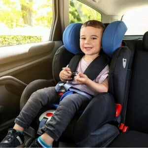 Um menino, sentado em um assento de elevação no carro, sorrindo e parecendo confortável. Um menino, sentado em um assento de elevação no carro, sorrindo e parecendo confortável.