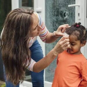 Mãe faz um curativo em criança que bateu a cabeça Mãe faz um curativo em criança que bateu a cabeça