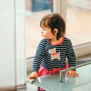 bebê em pé em uma mesa com protetor de quina bebê em pé em uma mesa com protetor de quina