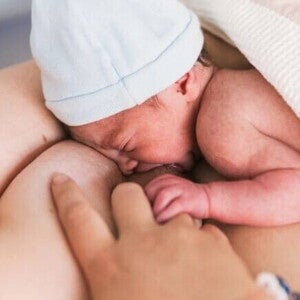 Recém-nascido sendo amamentado pela mãe Recém-nascido sendo amamentado pela mãe