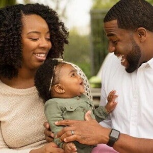 Mãe e pai sorrindo com o bebê no colo Mãe e pai sorrindo com o bebê no colo