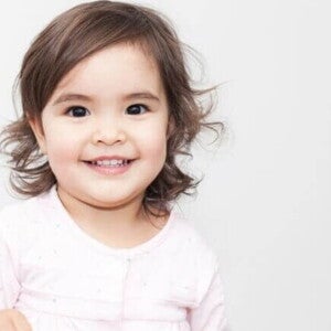 Bebê sorrindo, vestindo uma roupa rosa em um fundo branco. Bebê sorrindo, vestindo uma roupa rosa em um fundo branco.