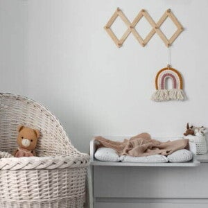 Quarto infantil com um berço ao lado de uma mesa em tons neutros. Quarto infantil com um berço ao lado de uma mesa em tons neutros.