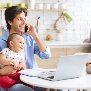 father talking on phone holding baby father talking on phone holding baby