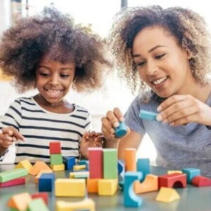 Mãe e filha brincam com blocos de montar para favorecer o desenvolvimento infantil Mãe e filha brincam com blocos de montar para favorecer o desenvolvimento infantil