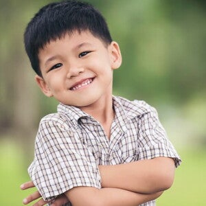 Menino asiático usando camisa xadrez sorrindo com os braços cruzados. Menino asiático usando camisa xadrez sorrindo com os braços cruzados.