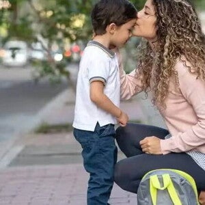 Guarda compartilhada Uma mãe se agacha para se despedir do filho durante a rotina da guarda compartilhada.