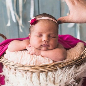 Fotógrafa ajustado adereço na cabeça de uma bebê recém nascida no ensaio fotográfico. Fotógrafa ajustado adereço na cabeça de uma bebê recém nascida no ensaio fotográfico.