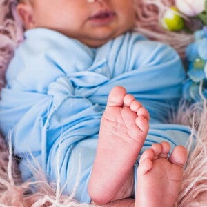 Ensaio fotográfico de bebê recém nascido deitado usando roupa azul claro. Ensaio fotográfico de bebê recém nascido deitado usando roupa azul claro.