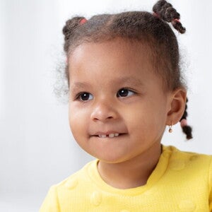 Menina vestindo blusa amarela e usando tranças no cabelo Menina vestindo blusa amarela e usando tranças no cabelo