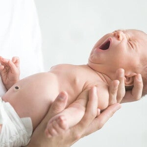Bebê recém nascido bocejando nos braços do pai. Bebê recém nascido bocejando nos braços do pai.