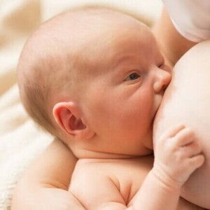 Um bebê recém-nascido sendo amamentado. Um bebê recém-nascido sendo amamentado.