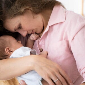 Mãe segurando e ninando o filho recém nascido