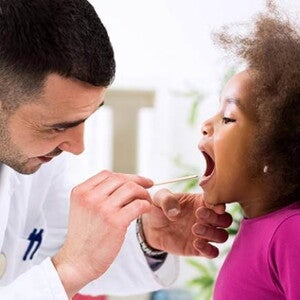 médico examinando a garganta de uma menina médico examinando a garganta de uma menina