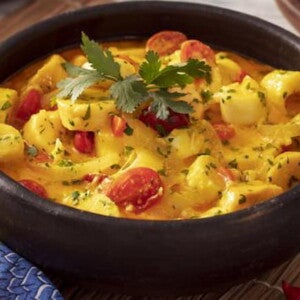Recipiente marrom com Moqueca de Banana da Terra com Palmito Recipiente marrom com Moqueca de Banana da Terra com Palmito