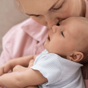 Mãe segurando no colo bebê recém nascido e beijando sua testa. Mãe segurando no colo bebê recém nascido e beijando sua testa.