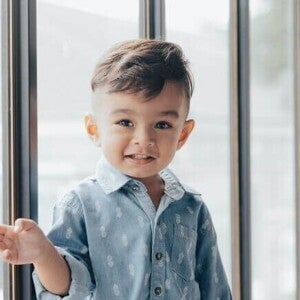 Menino sorrindo com uma camisa azul, com uma porta de vidro ao fundo. Menino sorrindo com uma camisa azul, com uma porta de vidro ao fundo.