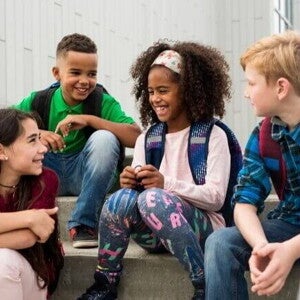 Um grupo de jovens sentados na escada e sorrindo Um grupo de jovens sentados na escada e sorrindo