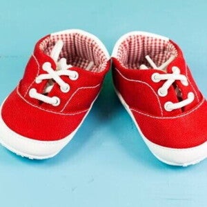 Par de sapatos de bebezinho vermelho, sobre um fundo azul. Par de sapatos de bebezinho vermelho, sobre um fundo azul.