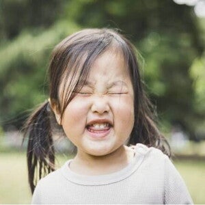 A foto destaca o rosto de uma menina fazendo caretas. A imagem remete ao tema de tique em crianças A foto destaca o rosto de uma menina fazendo caretas. A imagem remete ao tema de tique em crianças