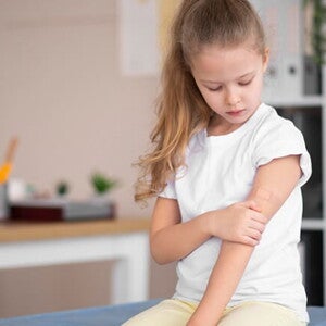 Uma criança sentada em um sofá segurando o braço Uma criança sentada em um sofá segurando o braço