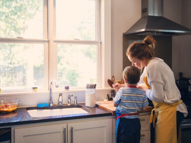 Criança ajudando um adulto na cozinha durante uma atividade juntos