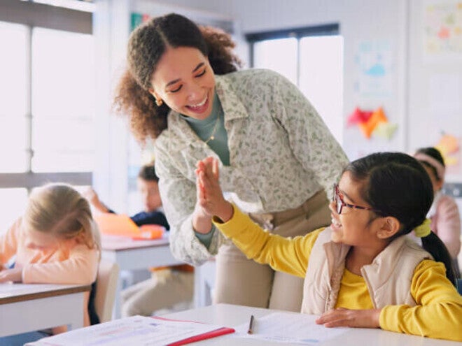 Criança estudando com livros e materiais escolares em uma mesa, representando aprendizado e desenvolvimento