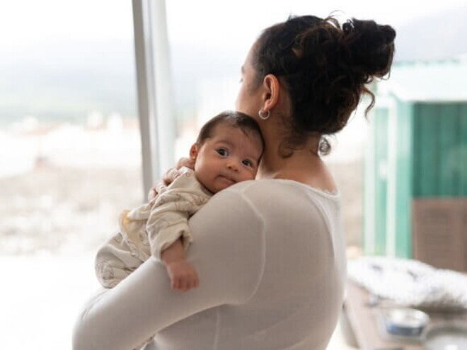 Mamãe segurando o bebê com o nariz entupido