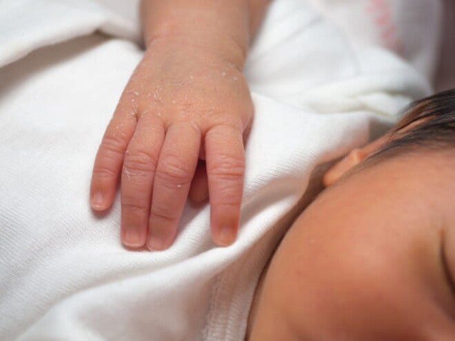 bebê recém nascido, com substância esbranquiçada em uma das mãos bebê recém nascido, com substância esbranquiçada em uma das mãos